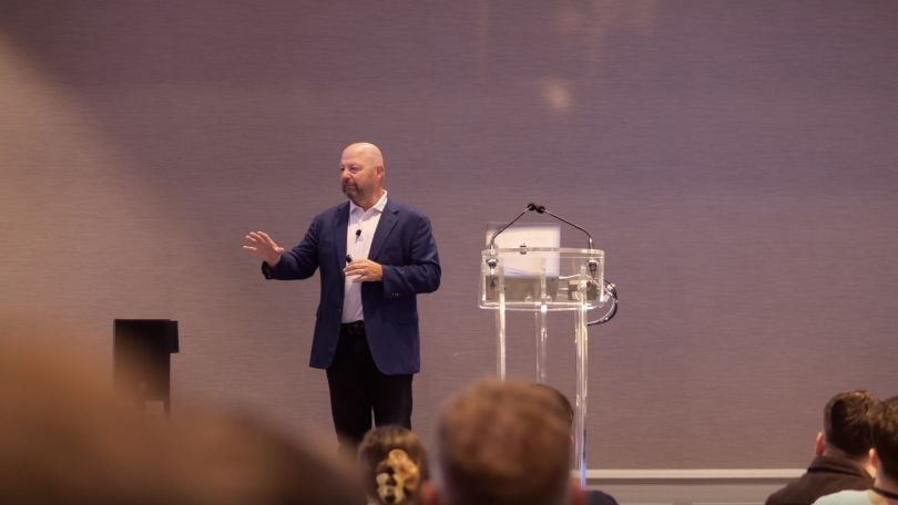 A photo of Pluralsight's Chief Revenue Officer Steve Vierra speaking on a stage. 
